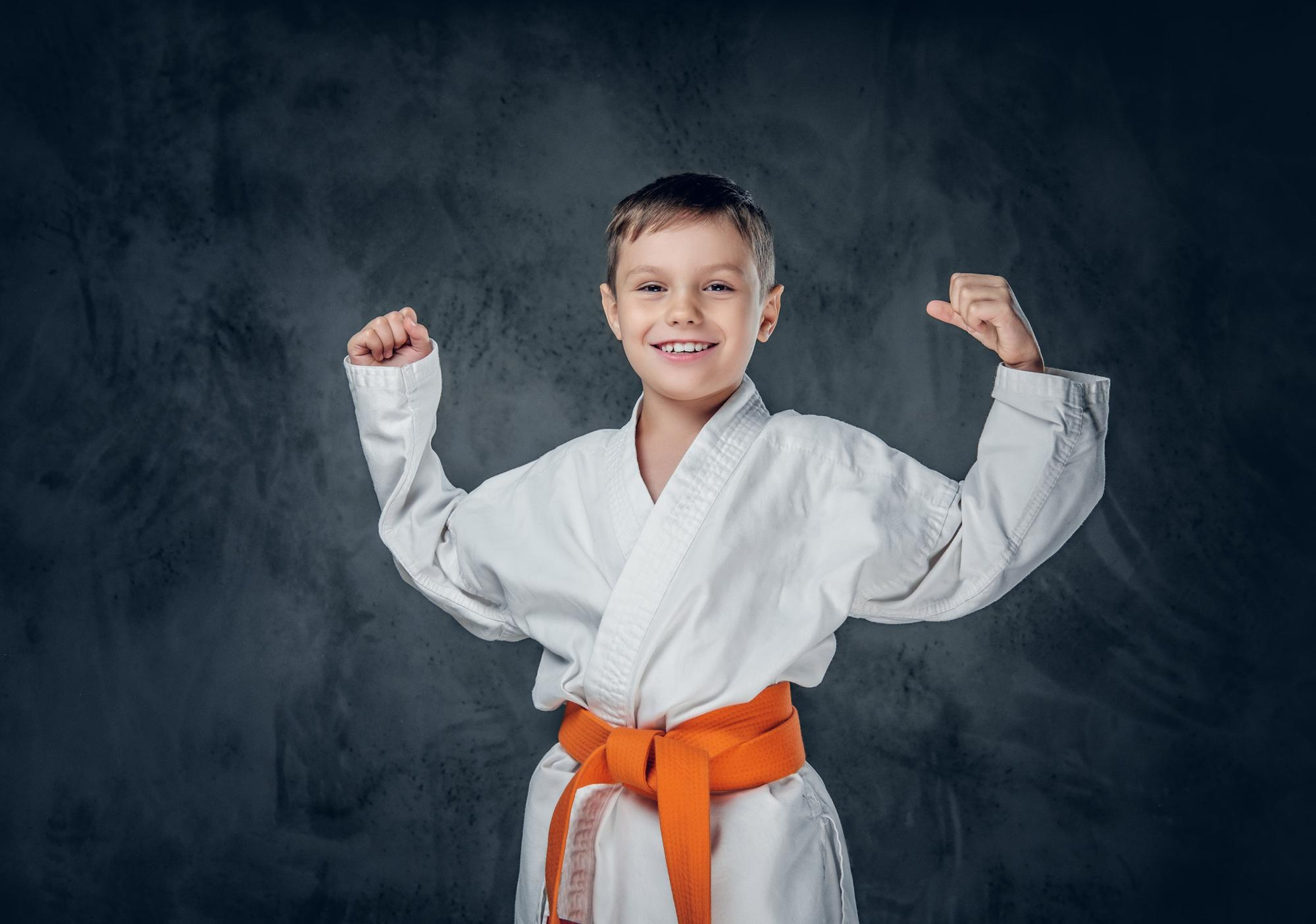 Preschooler-boy-dressed-white-karate-kimono-with-orange-belt