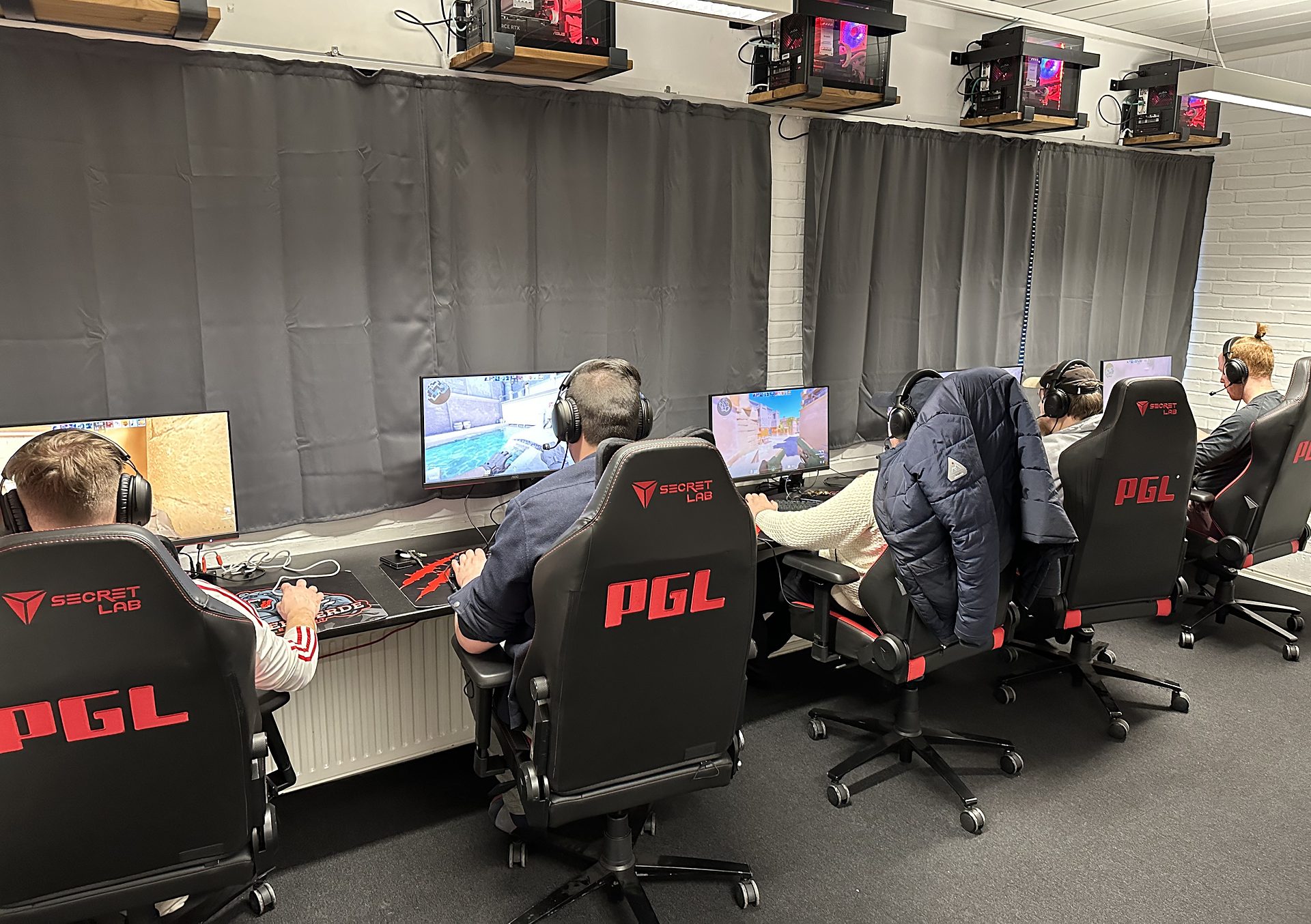 Spillere ved de fem gaming-pladser i det lille lokale