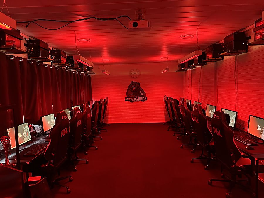 Det store lokale i rødt lys med gamerstole og PC'er langs væggene